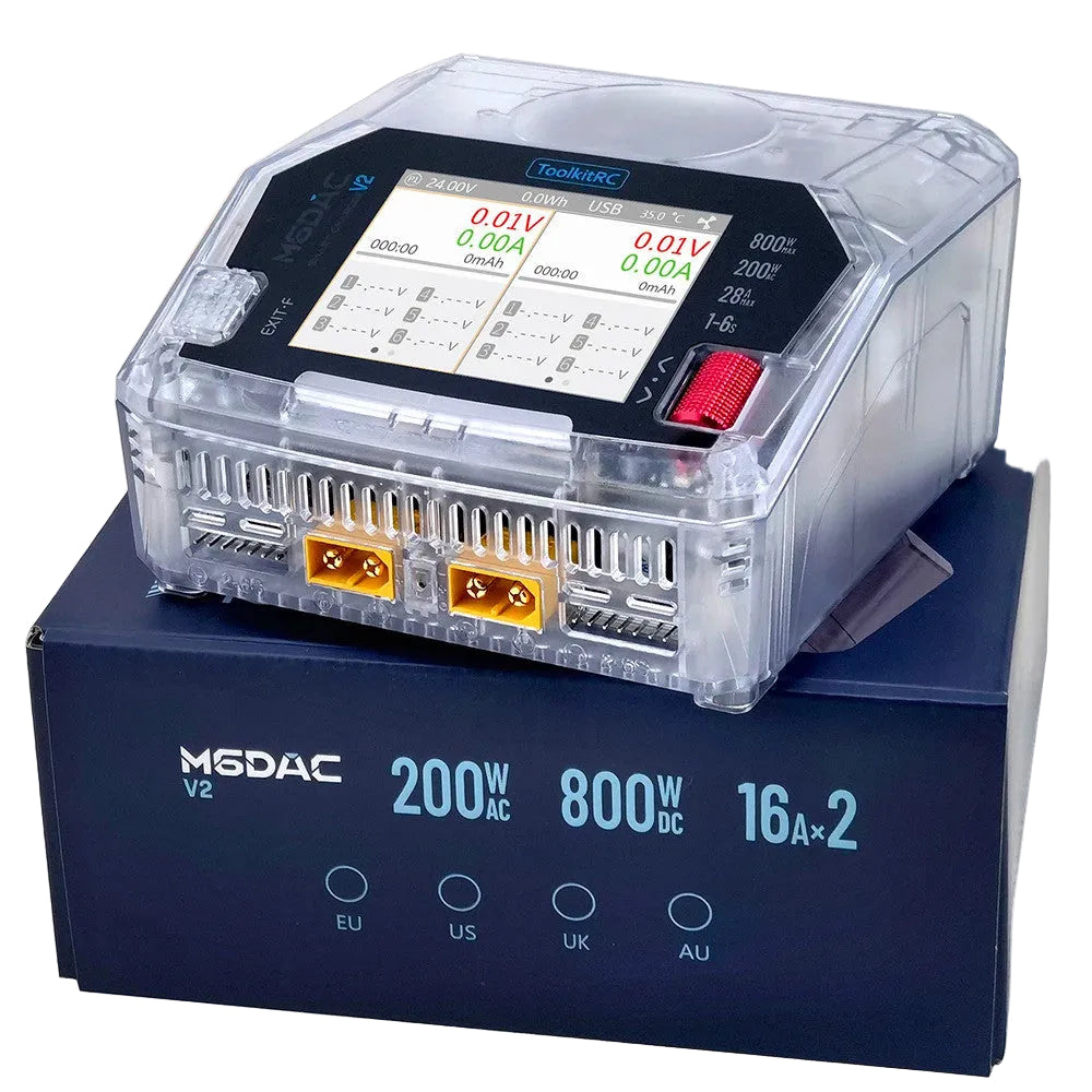 M6DAC V2 transparent tool kit RC transmitter battery charger and power supply shown on top of its dark blue retail box. The device has a clear plastic housing, a black control panel with a digital display, and orange terminal connectors on the front.